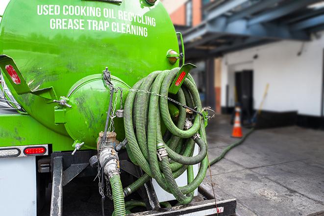 a technician pumping a grease trap in a commercial building in Anaheim CA